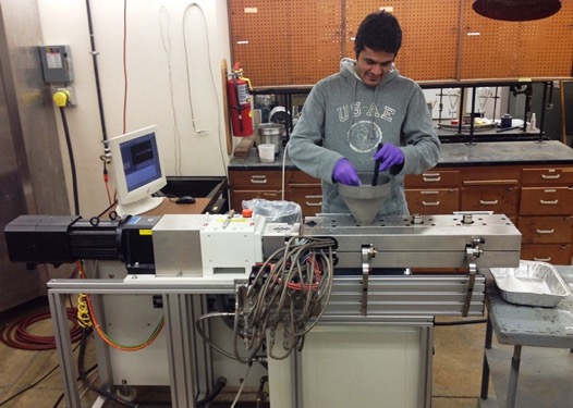 A student demonstrates extrusion equipment at the IAPC lab
